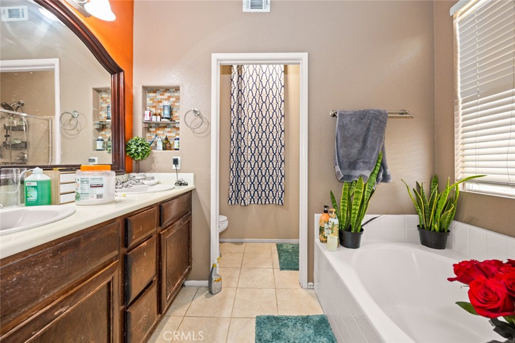 410 Windfields Way Beaumont, CA 92223 - Photo 17 of 41 a bathroom with a tub sink and mirror