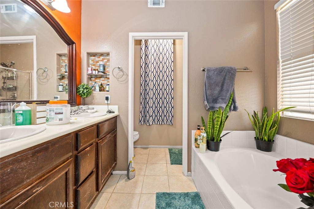 410 Windfields Way Beaumont, CA 92223 - Photo 17 of 41 a bathroom with a tub sink and mirror