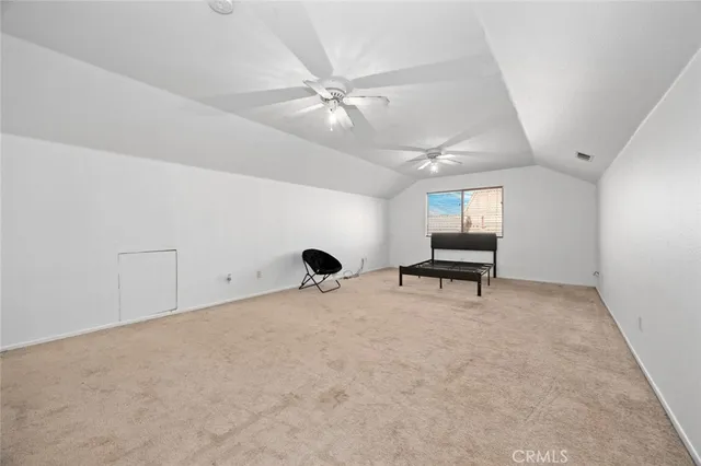 an empty room with windows and ceiling fan