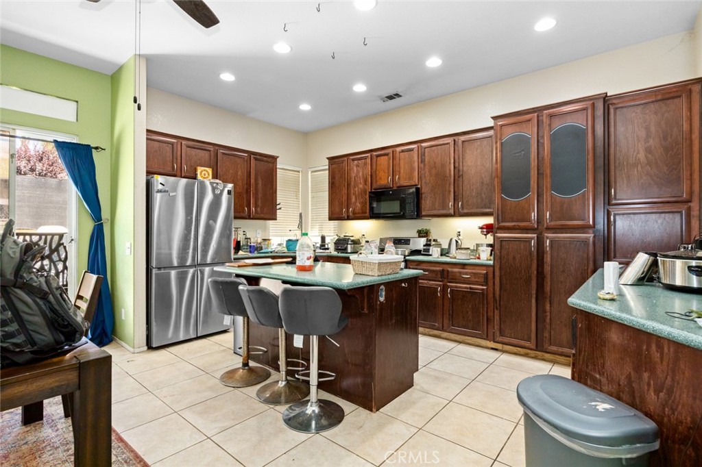 410 Windfields Way Beaumont, CA 92223 - Photo 6 of 41 a kitchen with a refrigerator a sink a stove a dining table and chairs