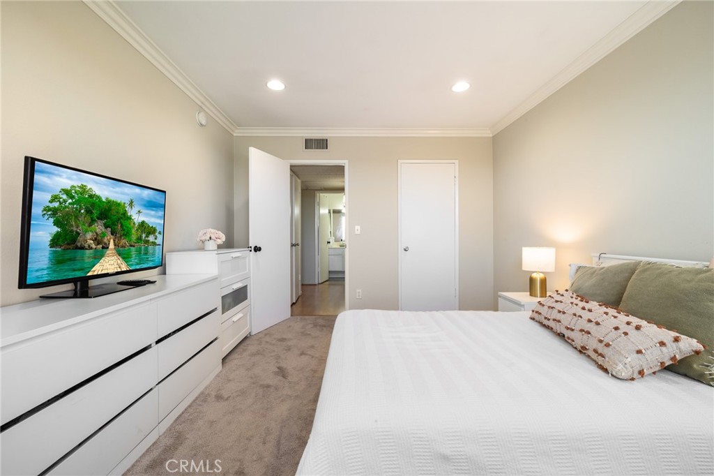 12830 Burbank Boulevard, Unit 307 Valley Village, CA 91607 - Photo 14 of 25 a spacious bedroom with a large bed and a flat screen tv