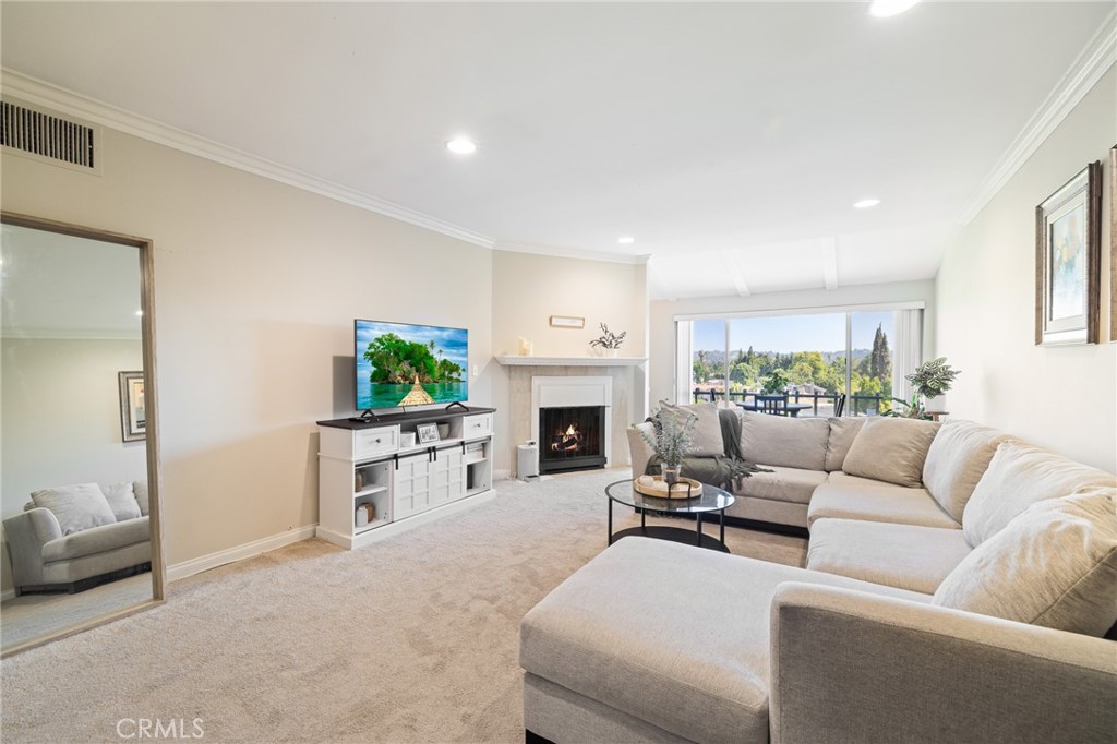 12830 Burbank Boulevard, Unit 307 Valley Village, CA 91607 - Photo 2 of 25 a living room with furniture a fireplace and a window