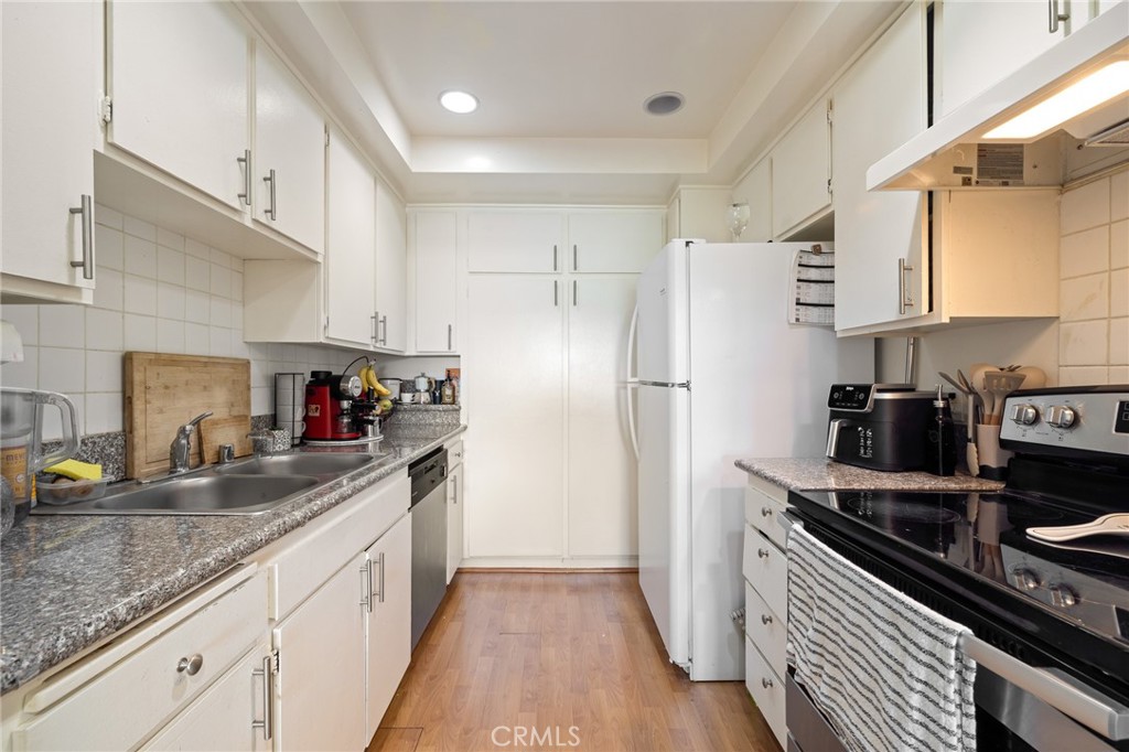 12830 Burbank Boulevard, Unit 307 Valley Village, CA 91607 - Photo 9 of 25 a kitchen with stainless steel appliances granite countertop a sink stove and refrigerator