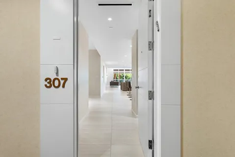 a large white kitchen with a sink counter top space and stainless steel appliances