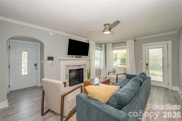 a living room with furniture a fireplace and a flat screen tv