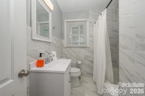 a bathroom with a sink a toilet and shower curtain