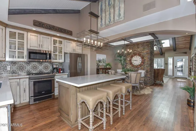 a kitchen with stainless steel appliances granite countertop a stove refrigerator and cabinets