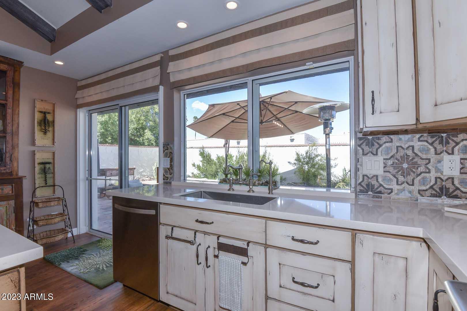 5804 North Scottsdale Road Paradise Valley, AZ 85253 - Photo 11 of 42 a kitchen with stainless steel appliances granite countertop white cabinets and a large window