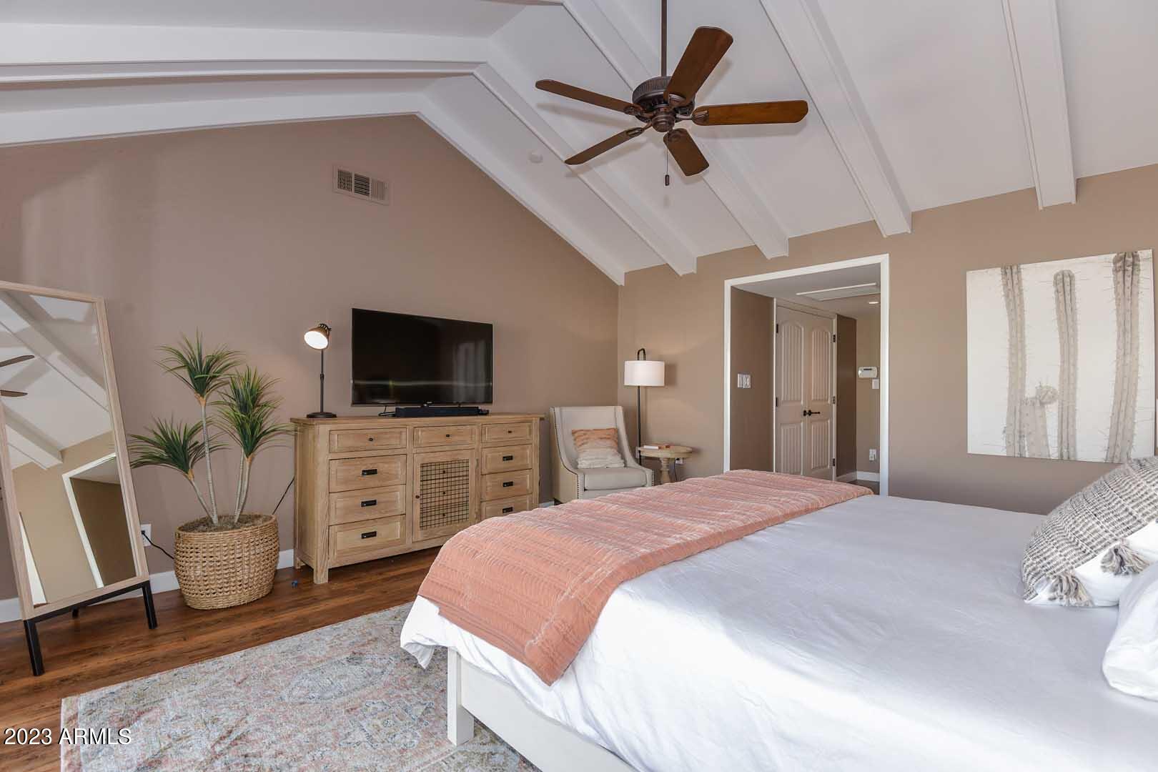 5804 North Scottsdale Road Paradise Valley, AZ 85253 - Photo 22 of 42 a bedroom with a bed a flat screen tv and a couch