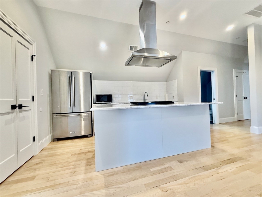 28 Dix Street, Unit 3 Boston, MA 02122 - Photo 16 of 34 a kitchen with stainless steel appliances a refrigerator and wooden floor