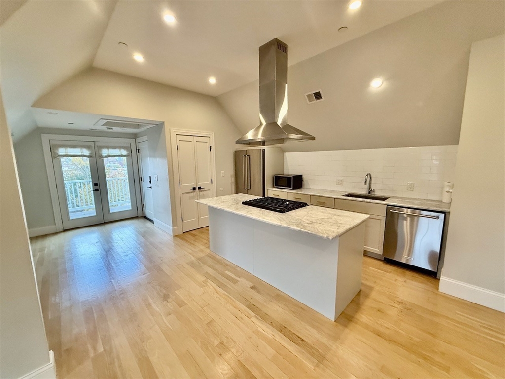 28 Dix Street, Unit 3 Boston, MA 02122 - Photo 7 of 34 a large kitchen with stainless steel appliances a large counter top a stove and a wooden floors