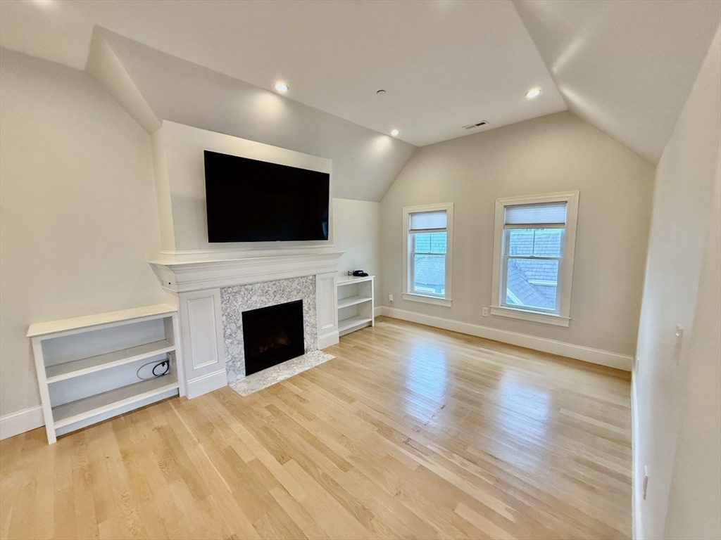 28 Dix Street, Unit 3 Boston, MA 02122 - Photo 10 of 34 a view of a livingroom with a fireplace a flat screen tv and staircase