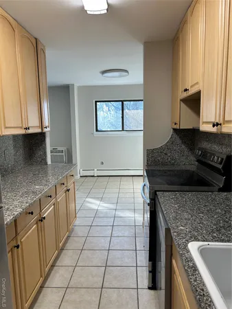 a kitchen with granite countertop a stove a sink and a microwave