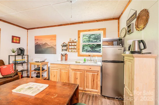 a kitchen with stainless steel appliances granite countertop a refrigerator a stove a sink a dining table and chairs with wooden floor