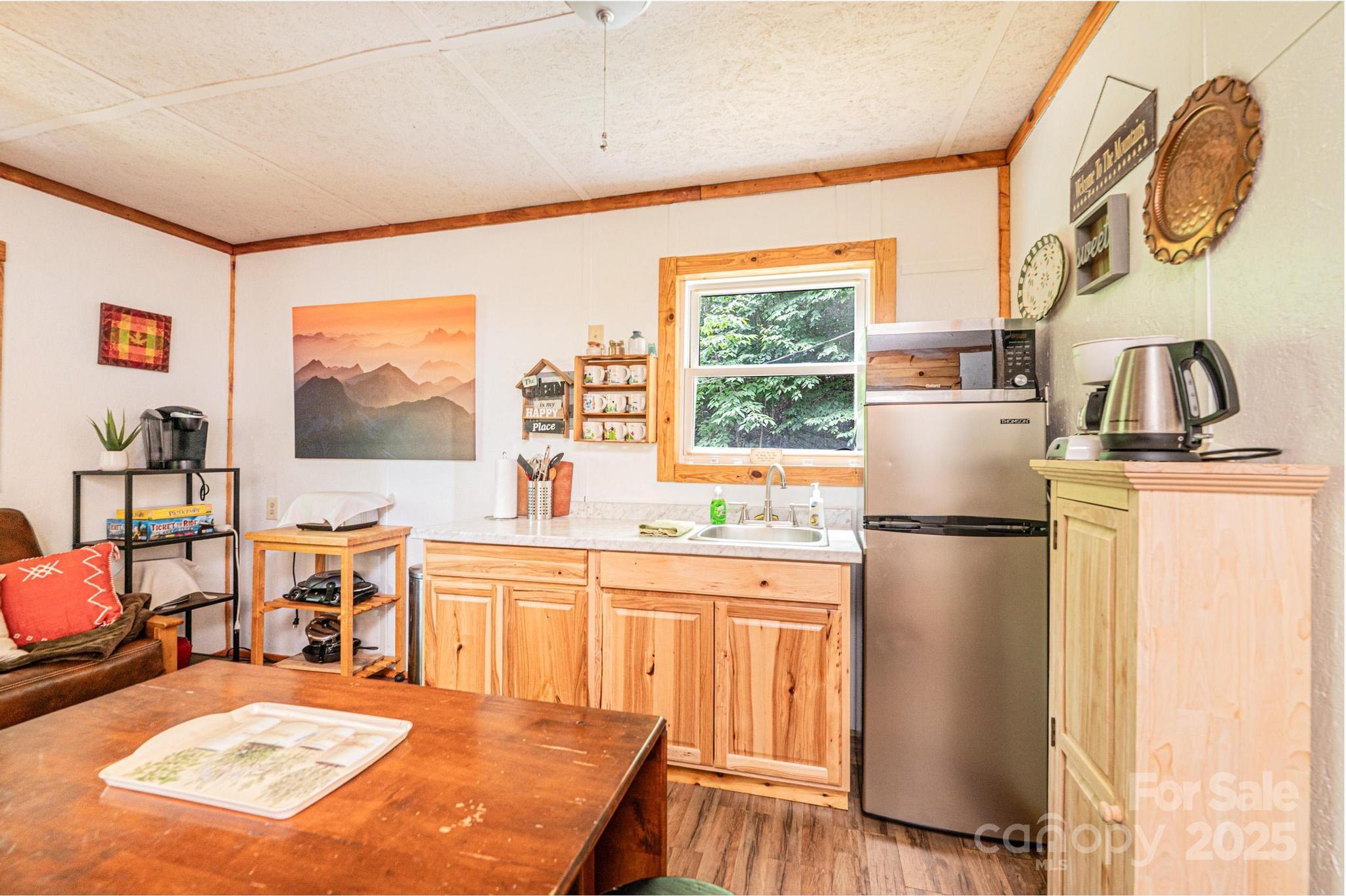 4462 Maple Grove Church Road Collettsville, NC 28611 - Photo 9 of 19 a kitchen with stainless steel appliances granite countertop a refrigerator a stove a sink a dining table and chairs with wooden floor
