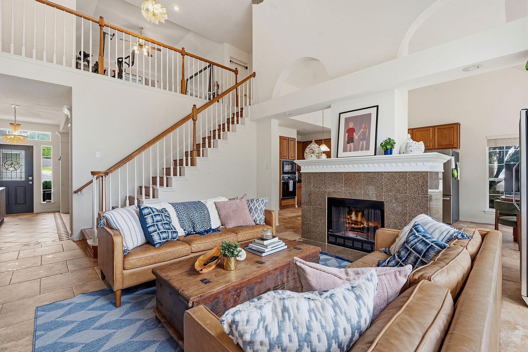 8317 Pommel Drive Austin, TX 78759 - Photo 4 of 26 A striking fireplace forms a focal point in this open-concept living space with an elegant staircase.