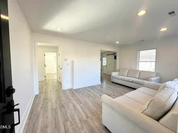 a living room with furniture and a wooden floor