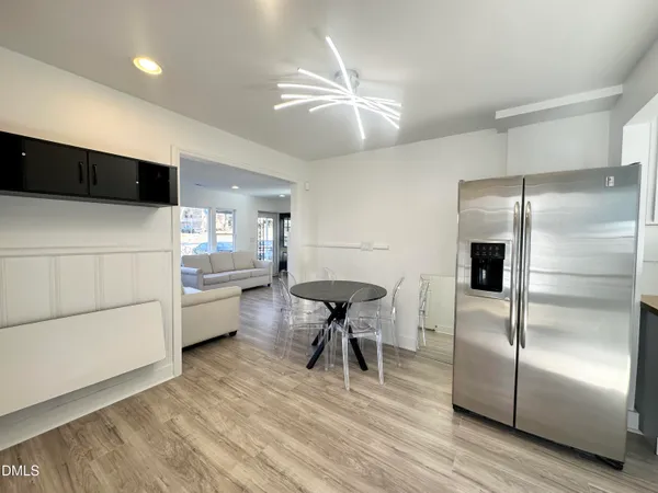 a kitchen with stainless steel appliances a refrigerator sink and white cabinets