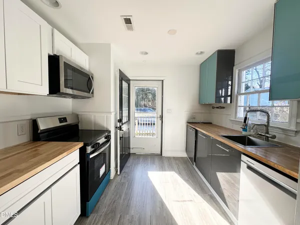 a kitchen with stainless steel appliances a sink dishwasher stove microwave and refrigerator