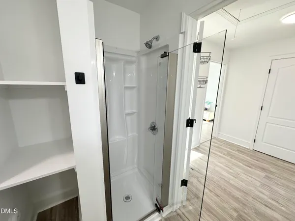 a bathroom with a shower and a glass door