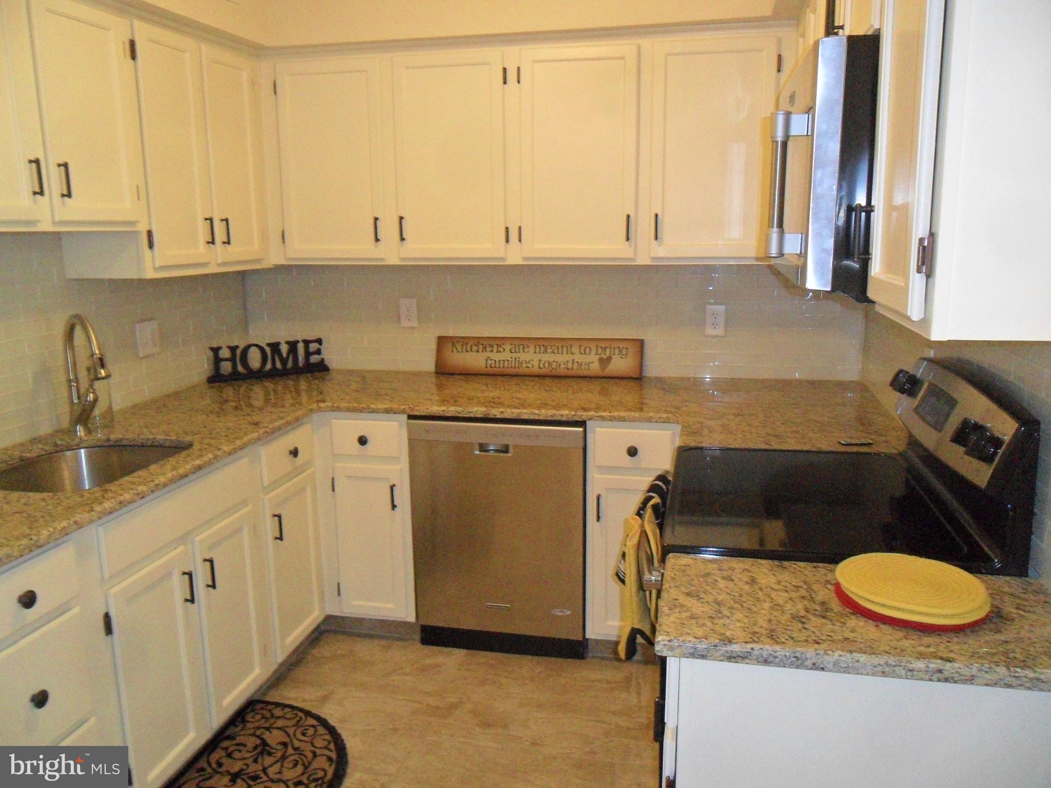 9 Delaware Street, Unit 9 New Castle, DE 19720 - Photo 3 of 28 a kitchen with granite countertop a sink a stove and cabinets