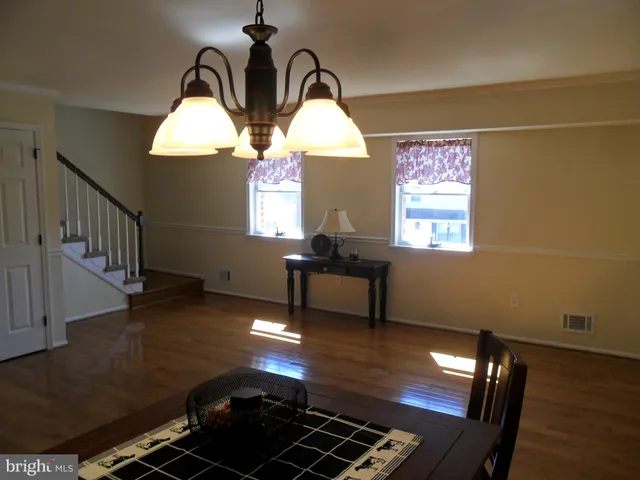 a room with wooden floor pool table and a window