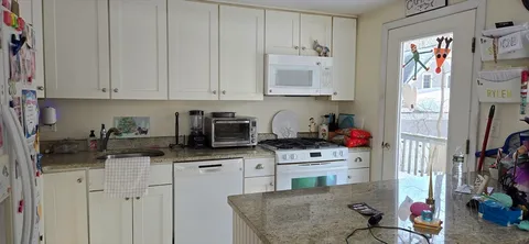 a kitchen with stainless steel appliances granite countertop a sink stove and cabinets