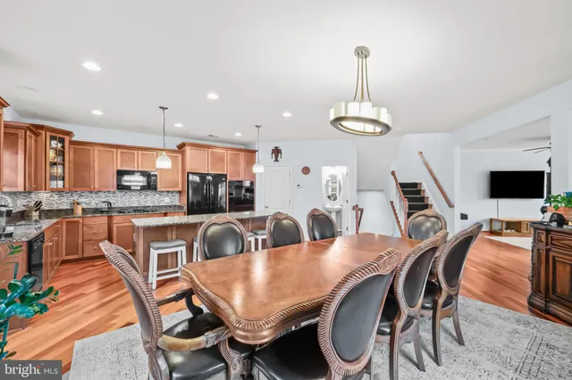 a view of a dining room and livingroom with furniture wooden floor a chandelier