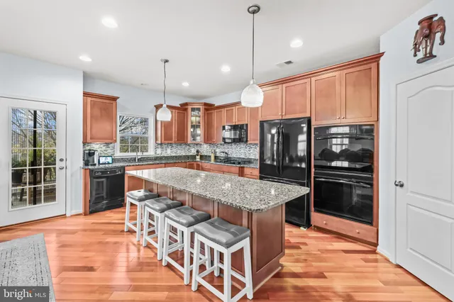 a kitchen with stainless steel appliances granite countertop a kitchen island a stove and a sink