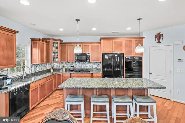 a kitchen with granite countertop a sink a counter top space and cabinets