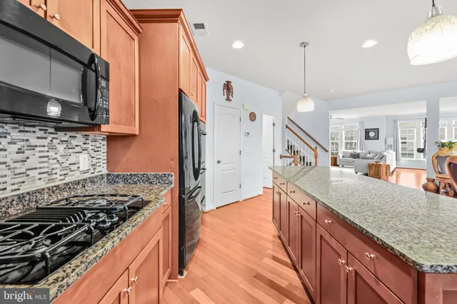 a kitchen with kitchen island a counter top space a sink appliances and cabinets