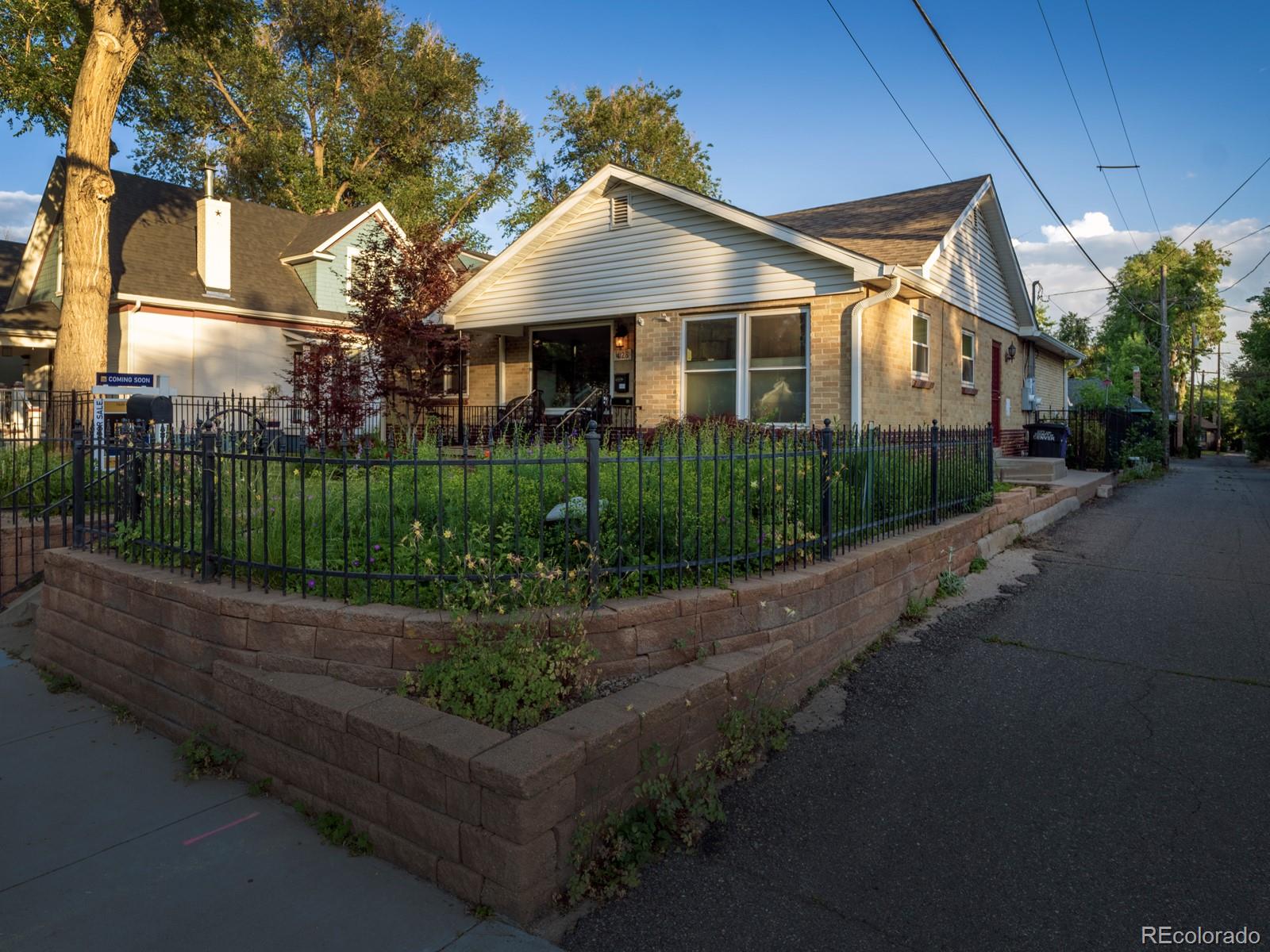4128 East 19th Avenue Denver, CO 80220 - Photo 1 of 34 a front view of a house with a yard and green space