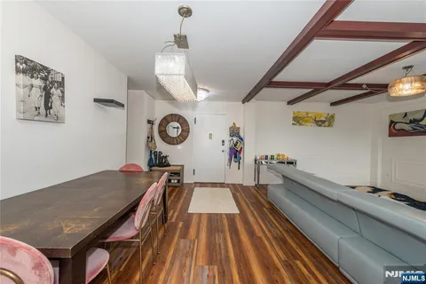 a room with wooden floor and lots of frames on the wall