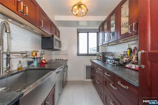 a kitchen with stainless steel appliances granite countertop a sink stove and cabinets