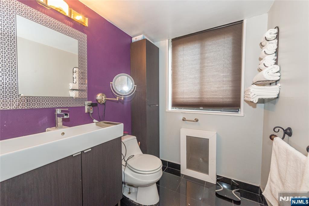90 Prospect Avenue, Unit 10A Hackensack, NJ 07601 - Photo 20 of 35 a bathroom with a sink a toilet and a mirror