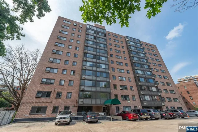 a view of road with card parked on road and trees