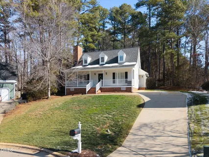 a view of a house with backyard and a tree