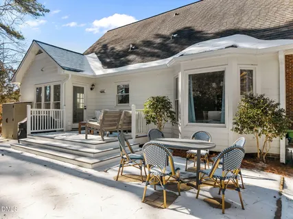 a view of a patio with table and chairs potted plants and a large tree