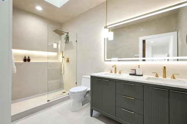 a bathroom with a sink toilet a mirror and shower