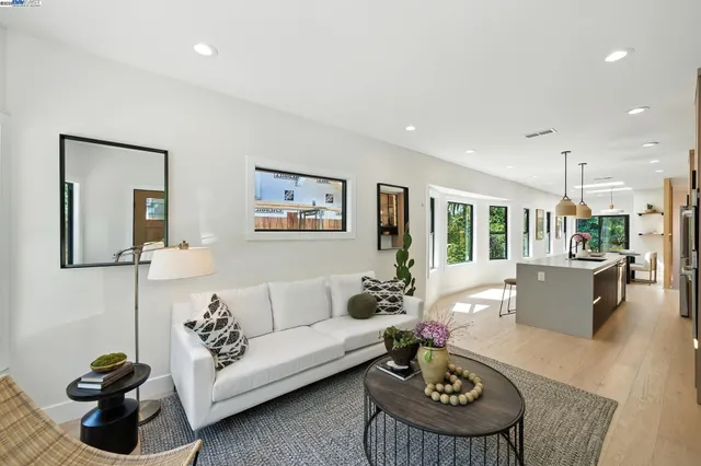 a kitchen with stainless steel appliances a stove a sink a microwave a refrigerator a stove and white cabinets