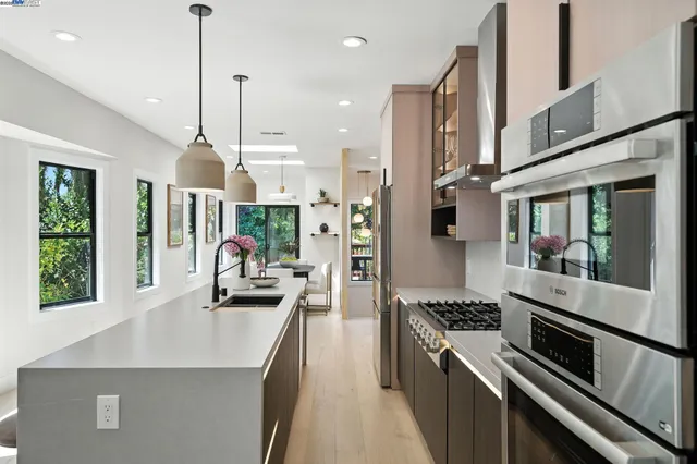 a kitchen with stainless steel appliances granite countertop a sink stove and refrigerator