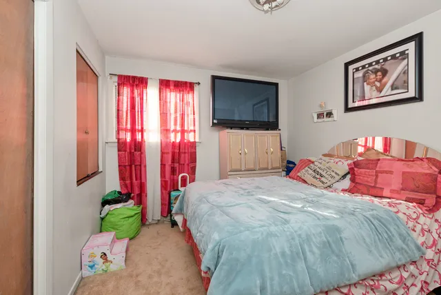 a bedroom with a bed and a flat screen tv