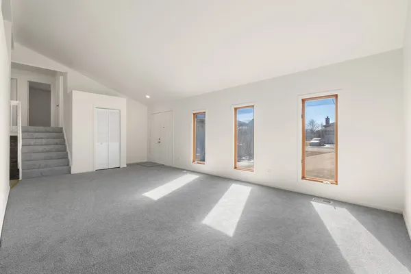 an empty room with windows and closet