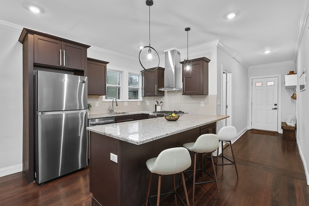 a kitchen with stainless steel appliances granite countertop a sink a refrigerator and a table