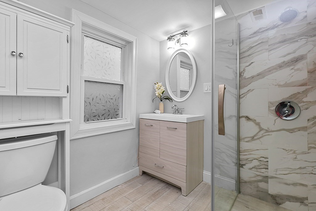 200-202 Elliot Street, Unit 1 Newton, MA 02464 - Photo 22 of 35 a bathroom with a toilet a sink and mirror