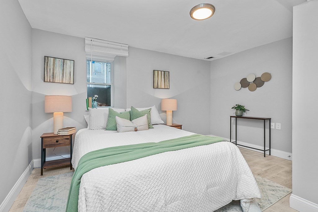 200-202 Elliot Street, Unit 1 Newton, MA 02464 - Photo 29 of 35 a bedroom with a bed and a lamp