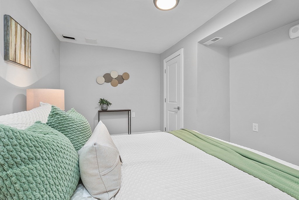 200-202 Elliot Street, Unit 1 Newton, MA 02464 - Photo 30 of 35 a bedroom with a bed and a painting on the wall