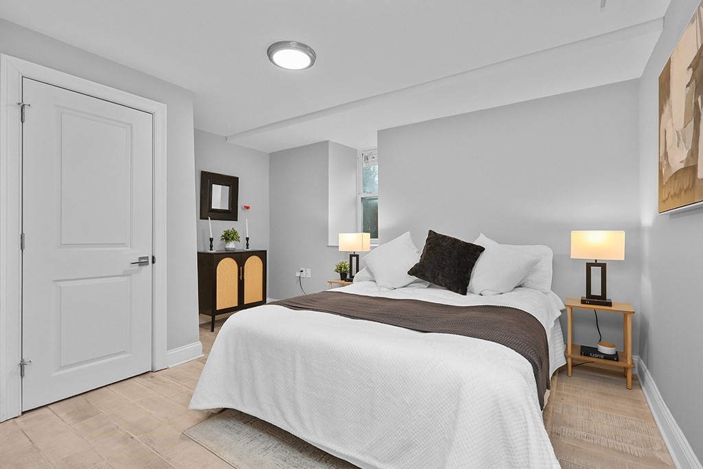 200-202 Elliot Street, Unit 1 Newton, MA 02464 - Photo 31 of 35 a bedroom with a bed and a lamp