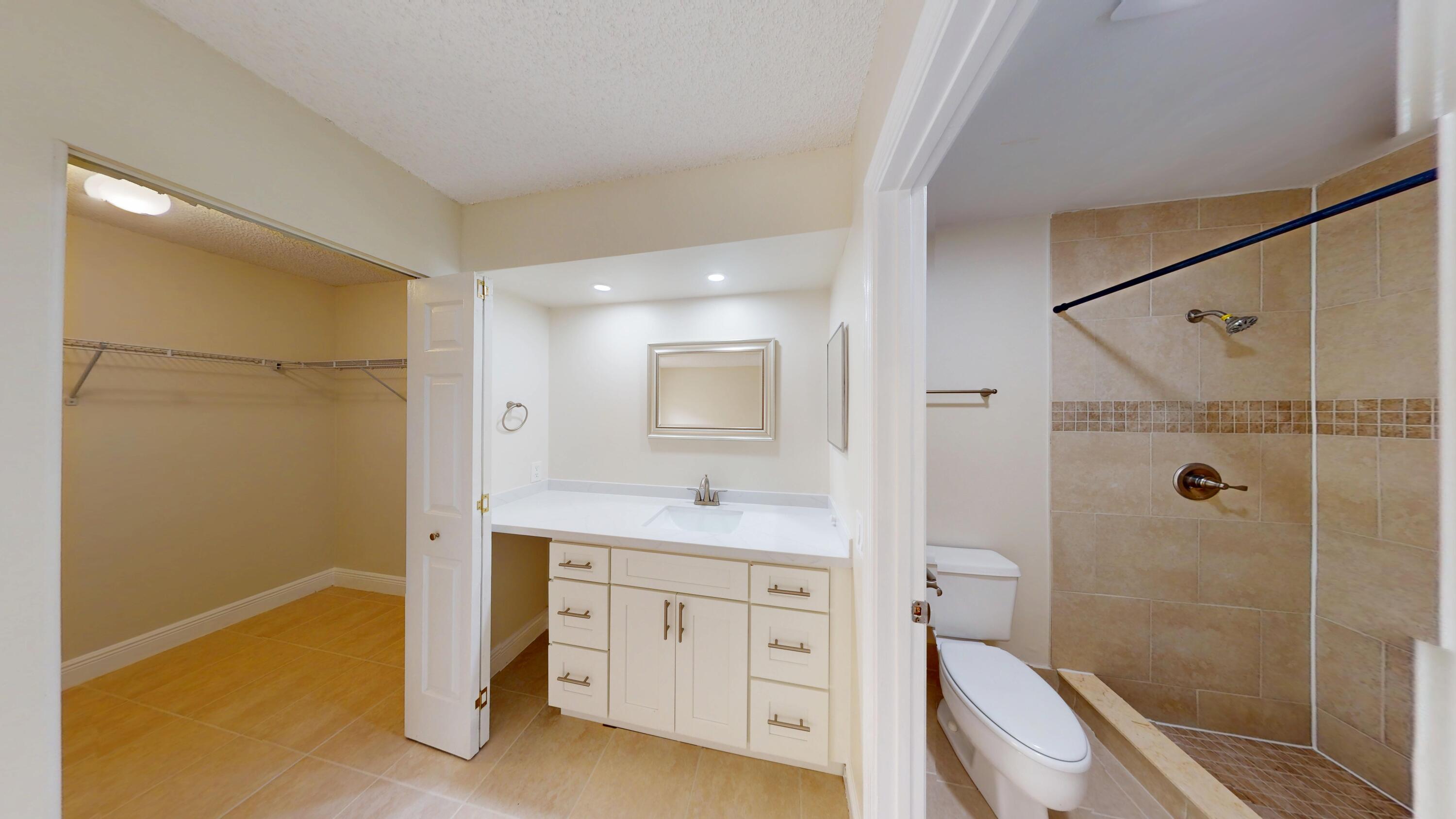 3143 Kingswood Terrace Boca Raton, FL 33431 - Photo 15 of 21 a bathroom with a granite countertop sink a mirror a vanity and shower