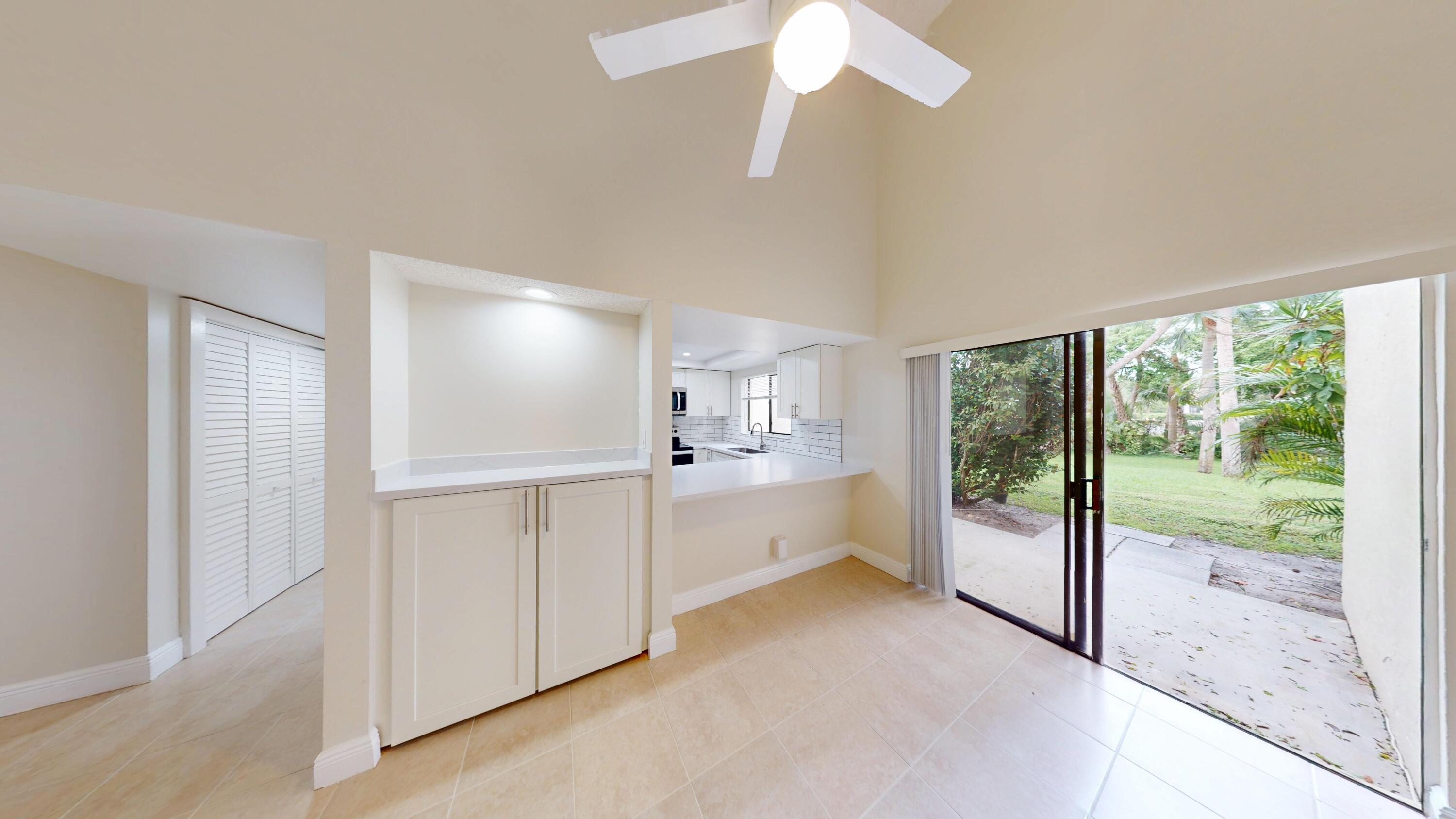 3143 Kingswood Terrace Boca Raton, FL 33431 - Photo 9 of 21 a large white room with a large window and chandelier